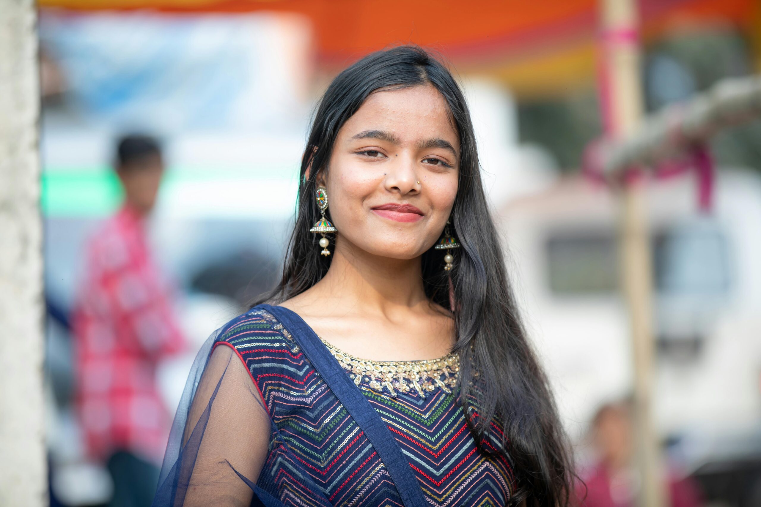Portrait of a young woman in colorful traditional Indian clothing at an outdoor event.